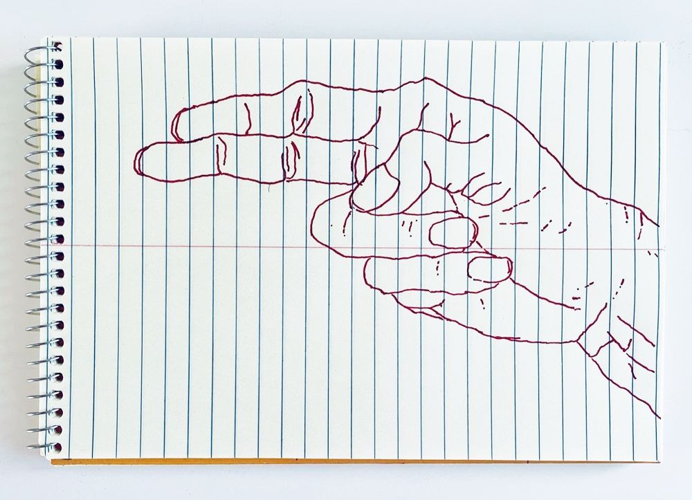 An outline handsketch of a hand shaping the ASL American manual letter “H”, in red ink on a yellow spiral bound steno notebook. 