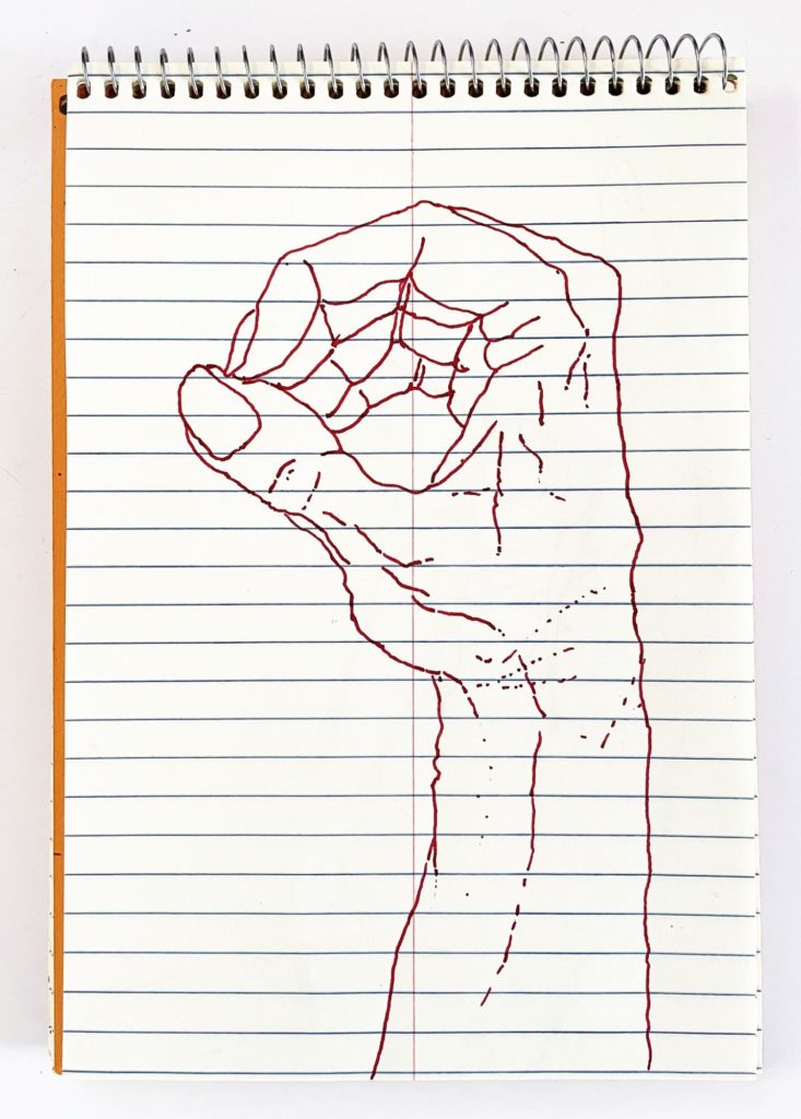 An outline handsketch of a hand shaping the ASL American manual letter “O”, in red ink on a yellow spiral bound steno notebook. 