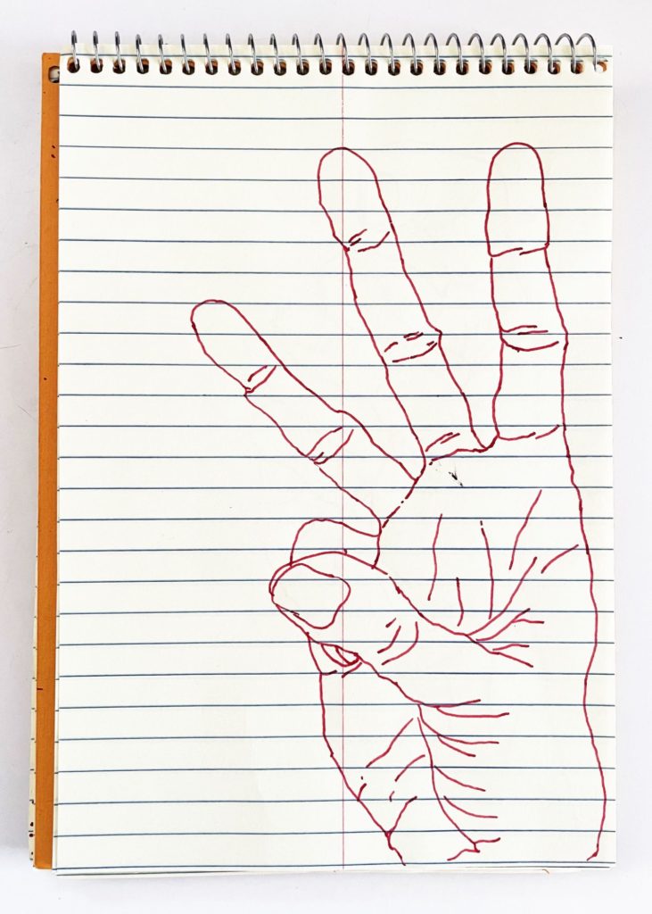 An outline handsketch of a hand shaping the ASL American manual letter “W”, in red ink on a yellow spiral bound steno notebook. 