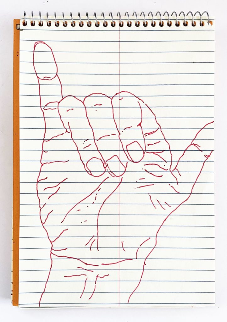 An outline handsketch of a hand shaping the ASL American manual letter “Y”, in red ink on a yellow spiral bound steno notebook. 