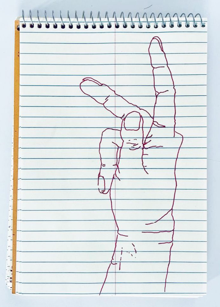 An outline handsketch of a hand shaping the ASL American manual letter “K”, in red ink on a yellow spiral bound steno notebook. 